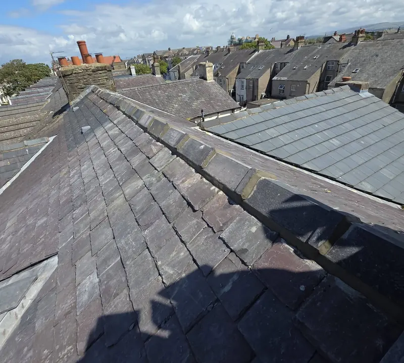 Slate roof and ridge on a terraced house, looking across rows of terraced rooftops
